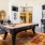 a room with a pool table and chairs