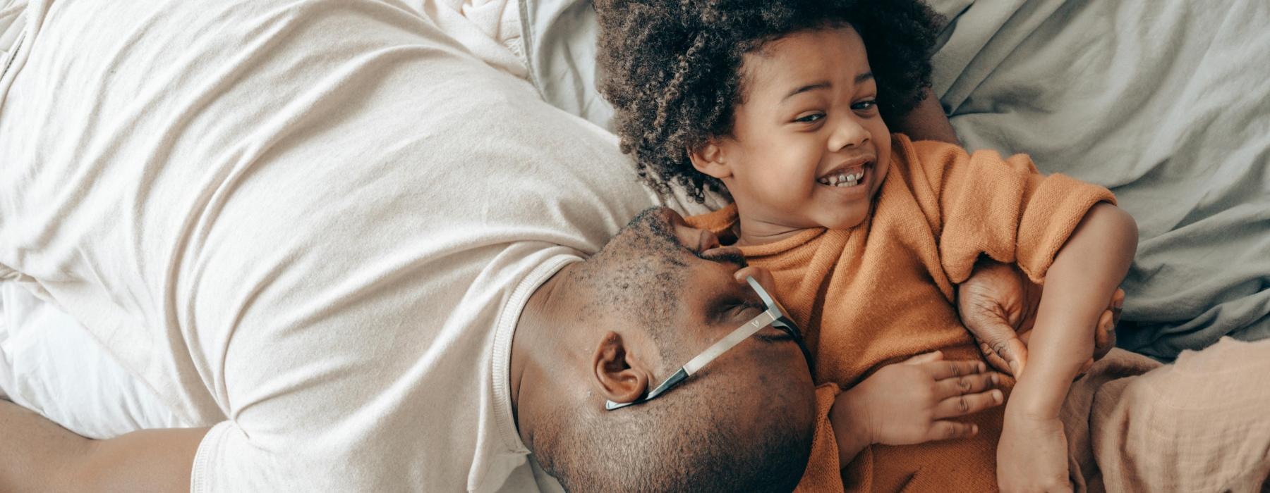 a person and a child lying in bed