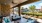 a living room with a fence and a patio with a large glass wall