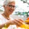 a woman smiling and holding a bunch of vegetables